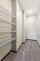 An oversized walk-in closet with several built-in wire shelves.