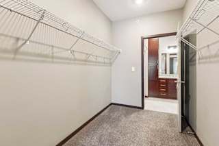 An oversized walk-in closet with several built-in wire shelves.
