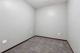 A carpeted den space with several outlets.