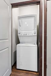 A stacked full-sized washer and dryer in a laundry room.