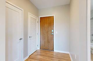 A front entryway with a wooden front door and a closed laundry room door.
