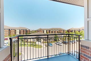A balcony with a metal railing and a view of the community.