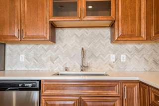 Ascend at Woodbury luxury apartment with herringbone backsplash in kitchen
