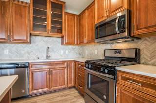 Premium design scheme with custom cabinetry and herringbone backsplash at Ascend at Woodbury MN 55129 new luxury apartments