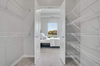 Large walk in closet with double doors and wire shelves on each side in 2 bedroom apartment in Woodbury MN 55125