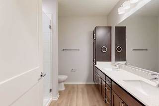 A bathroom with a toilet, sink, and mirror.