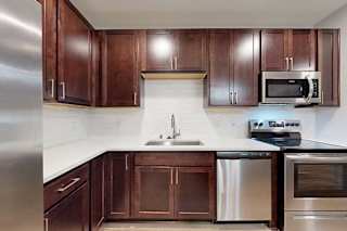 A kitchen with brown cabinets and stainless steel appliances.