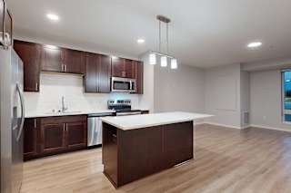 A kitchen with brown cabinets and a white counter.