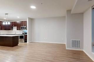A spacious kitchen with dark wood cabinets and a white countertop.
