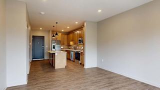 A kitchen with a wooden floor and white walls.