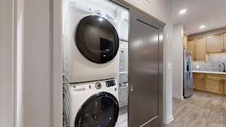 In-home apartment laundry closet with a stacked washer and dryer, conveniently located just off the kitchen.