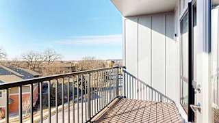 a balcony with a black metal railing and a view of the Villas at Wilderness Ridge across the street