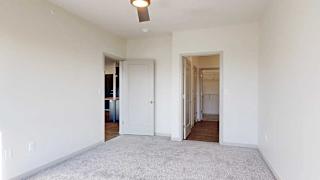 a bedroom with carpeted flooring, an attached bathroom, and a walk-in closet connected via the bathroom