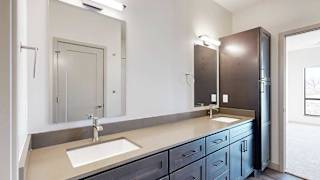 a bathroom with a double vanity sink, two mirrors, and a tall dark wooden storage cabinet