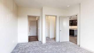 a bedroom with carpeted flooring, a walk-in closet, and an attached bathroom