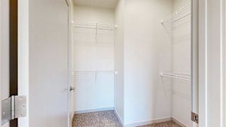an L-shaped walk-in closet with built-in shelving