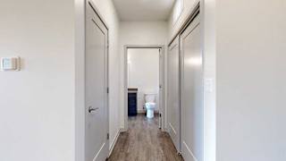 a hallway with two closets and an open door to a bathroom
