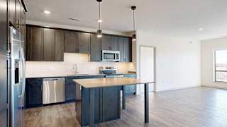 a modern kitchen with dark wood cabinets and stainless steel appliances