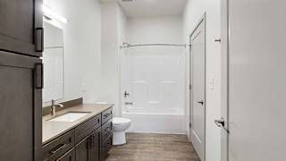a bathroom with a wide vanity sink, a tall cabinet, and a shower