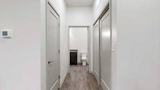 a hallway with a door open to the bathroom, a closed entryway closet, and closed laundry room