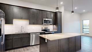a modern kitchen with dark wood cabinets and stainless steel appliances