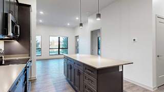 a modern kitchen with dark cabinets and a large island