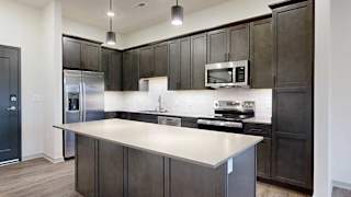 a modern kitchen with dark wood cabinets and stainless steel appliances