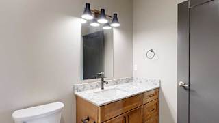 a bathroom with a white quartz sink and a mirror