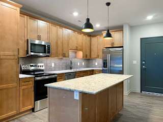A kitchen with wooden cabinets and a granite countertop.