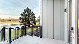 a balcony facing out toward apartment buildings and green space