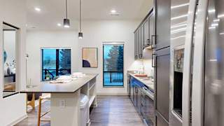 a modern kitchen with white quartz countertops and overhead cabinets