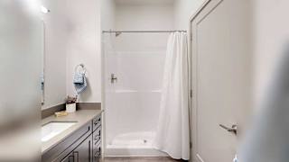a bathroom with a large mirror, vanity, and modern lighting