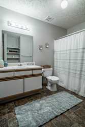 A bathroom with a toilet, sink, and shower.
