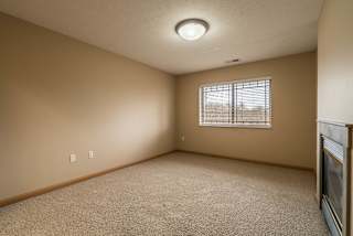 an empty bedroom with a window and carpet