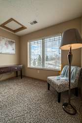 a living room with a lamp and a chair and a window