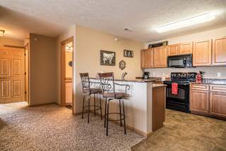 a kitchen with a bar with three stools