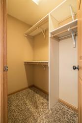 a walk in closet in a home with a door open