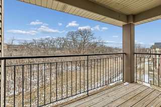 Spacious covered balcony with railing and elevated views.