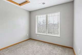 Carpeted bedroom with window and ceiling light.