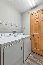 A laundry room with a washer and dryer and a wooden door.