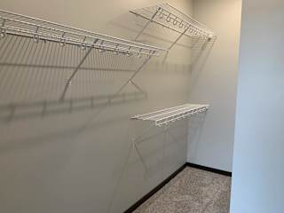 Walk in closet with one full wall of wire wracks for storage and hanging