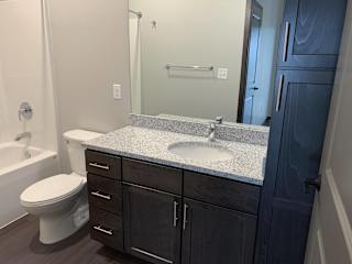 Bathroom with dark brown vanity and linen cabinet for storage and large mirror