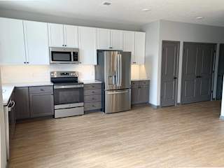 Spacious open kitchen with matching steel appliances and under cabinet lighting in serenity floorplan at Haven at Uptown