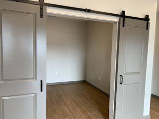 Sliding gray barn doors to the spacious office area or den