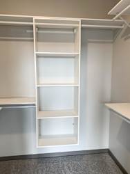 All white shelving and rods in walk in closet in serenity floor plan at Haven at Uptown
