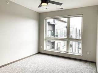Carpeted bedroom with large floor to ceiling window