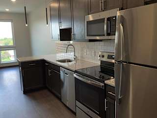 Kitchen with matching stainless steel appliances in Zen floorplan at Haven at Uptown