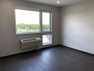 Living area with dark wood style floors with large windows and city view