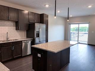 kitchen with lots of storage cabinets in a warm mocha finish at Haven at Uptown