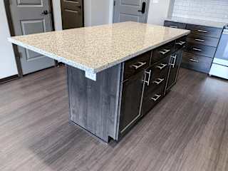 Kitchen island with light granite counters, warm mocha cabinets and storage